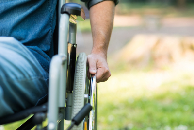 detail of a man using a wheelchair in a park